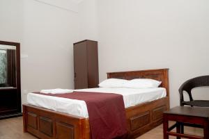 a bedroom with a bed and a chair at G K Guest House in Kalkudah