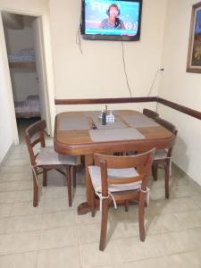 a wooden table and chairs with a television on a wall at a TRES MIN DEL CENTRO in Concordia