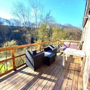 a deck with chairs and a table and a bench at Chez Madame Irma in Sougné-Remouchamps