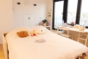 three stuffed animals sitting on top of a bed at Cozy Rooftop - Sint-Idesbald in Koksijde +17 photos