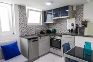 a kitchen with stainless steel appliances and a blue pillow at Nautica Luxe Beachfront in Oroklini