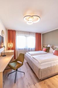 a bedroom with a large bed and a desk and a chair at Starzel Rooms in Alling