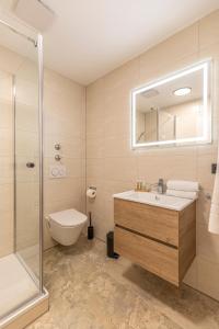 a bathroom with a sink and a shower and a toilet at Starzel Rooms in Alling