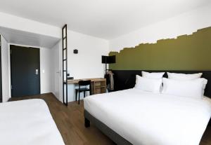 a hotel room with two beds and a desk at B&B HOTEL Nyon in Nyon +22 photos