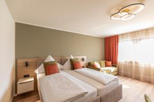a bedroom with two beds and a couch and a window at Starzel Rooms in Alling