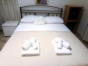 a bed with towels and a stuffed animal on it at sunwave Tolo in Tolo