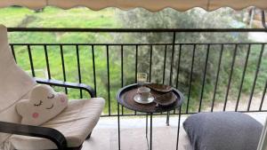 a balcony with a coffee table and a glass of wine at sunwave Tolo in Tolo