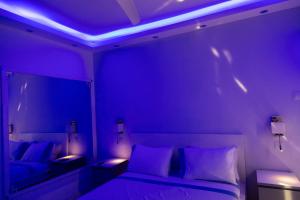a bedroom with a bed and a mirror with purple lights at Nautica Luxe Beachfront in Oroklini