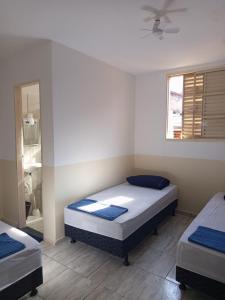 a bedroom with two beds and a window at Hospedaria Barão in Campinas