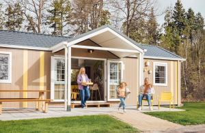 a family standing outside of a tiny house at Familie Resort de Tovertuin in Hoogerheide