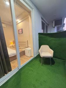 a room with a window and a chair and a bedroom at Aarcos Stays in Greater Noida