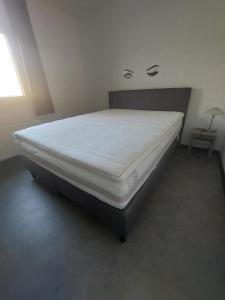 a bed in a room with a white mattress at La Casa Bianca gîte 4 pers in Lierneux