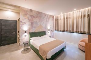 a bedroom with a bed and a painting on the wall at Lamal Hotel Napoli in Naples