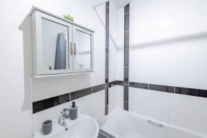 a white bathroom with a sink and a mirror at Wanderer's Rest in Lynton +17 photos