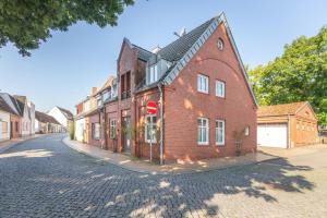 a red brick building on a cobblestone street at Dat lütte Huus - Wohnung 1 in Husum