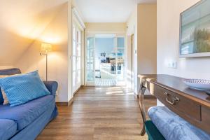 a living room with a blue couch and a table at Dat lütte Huus - Wohnung 1 in Husum