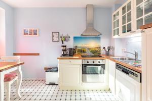 a kitchen with white cabinets and a sink at Dat lütte Huus - Wohnung 2 in Husum