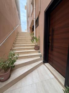 a staircase with potted plants next to a door at Modern Studio Near Al Haram And City Center Self Check-in in Medina