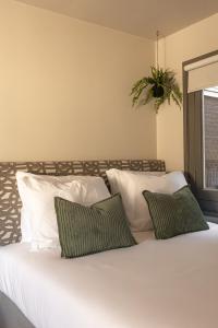 a bed with white pillows and a plant above it at Hotel Central Staytion in Amsterdam