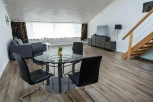 a living room with a glass table and chairs at Muota River Loft & Muota Industry Apartment near Stoos in Muotathal