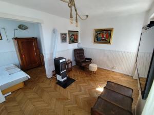 a living room with a wooden floor and a chair at Paloznak Retrospektív in Paloznak +26 photos