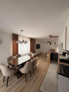 a kitchen and living room with a table and chairs at Apartmani EMA SL in Vranje