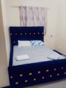a blue bed in a room with a window at Explore Rock city Mwanza in Mahango