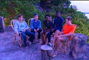 a group of men sitting in chairs on the beach at Explore Rock city Mwanza in Mahango