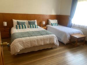 a bedroom with two beds and a window at CHALET CHAPITAL Punta Arenas in Punta Arenas