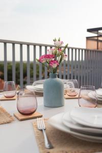 a table with plates and a vase with flowers on it at Cozy Rooftop - Sint-Idesbald in Koksijde