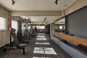 a gym with several treadmills and a large mirror at Studio Luggo Pampulha in Belo Horizonte
