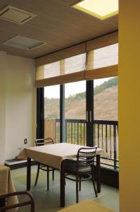 a table and chairs in a room with a large window at 光沙の森 in Hakone +28 photos