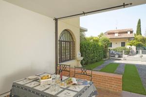 a table with a bowl of fruit on a patio at Villetta Gro - Gardagate in Sirmione
