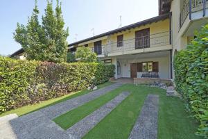 a cat sitting on the grass in front of a building at Villetta Gro - Gardagate in Sirmione