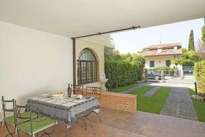 a patio with a table and chairs and a yard at Villetta Gro - Gardagate in Sirmione