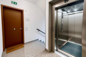 an elevator in a building with a welcome sign next to a door at Civico 44 - vicino al Centro Storico, Ospedale e Centro Iperbarico in Ravenna
