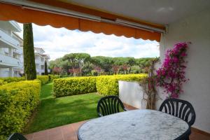 a patio with a table and chairs and a garden at GREEN MAR F 102 in Pals