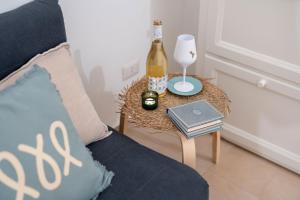 a bottle of wine sitting on a table next to a couch at Dimora Sardaro Suites by BarbarHouse in Monopoli