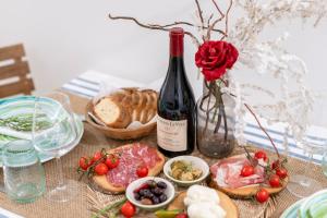 a table with a bottle of wine and some food at Dimora Sardaro Suites by BarbarHouse in Monopoli