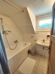 a bathroom with a shower and a tub and a sink at Stockerhütte - Ferienhaus in Vorderstoder +4 photos