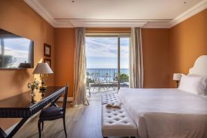 a bedroom with a bed and a desk and a window at Villa della Pergola Relais et Chateaux in Alassio