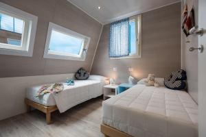 a bedroom with two beds and a teddy bear at Bungalow Marina Azzurra in Lignano Sabbiadoro +46 photos