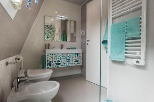 a bathroom with a toilet and a sink and a mirror at Bungalow Marina Azzurra in Lignano Sabbiadoro
