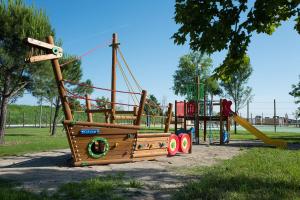 a playground with a pirate ship on it in a park at Bungalow Marina Azzurra in Lignano Sabbiadoro