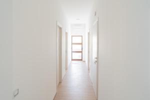 an empty corridor with white walls and a white door at Il Sogno B&B Latronico Terme e Parco del Pollino in Latronico
