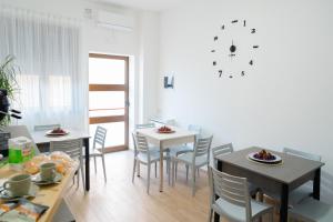 a dining room with tables and chairs and a clock on the wall at Il Sogno B&B Latronico Terme e Parco del Pollino in Latronico