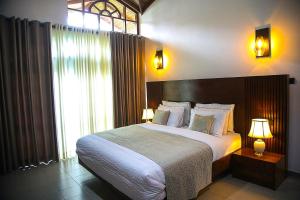 a bedroom with a large bed and a large window at The Heavens Villa - Colombo & BIA Airport in Ja-Ela