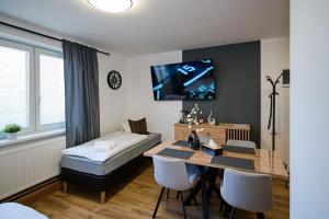a living room with a table and a bed and a tv at U Šípků in Ostrava
