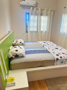 a small bedroom with a bed with a green headboard at Appartement d'une chambre salon in Wonyomé