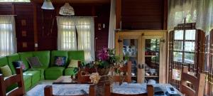 a living room with a green couch and a table at Casa de Campo em Monte Verde in Camanducaia